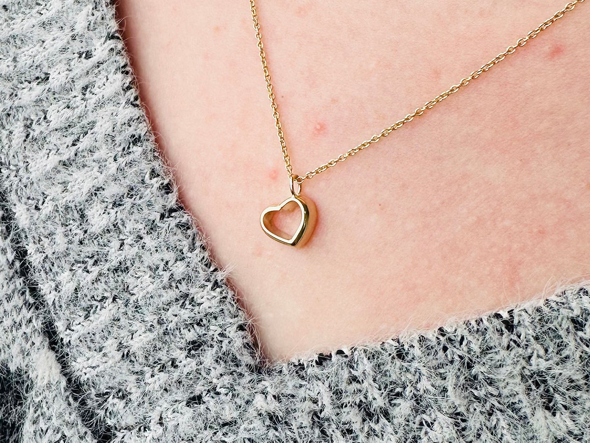 Woman wearing gold heart necklace