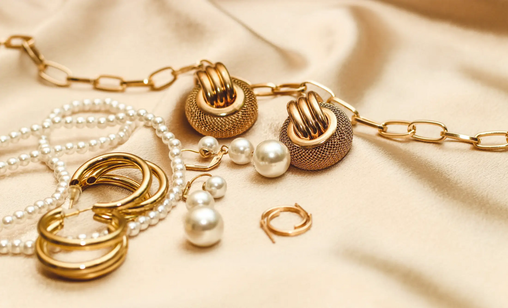 gold jewelry laid out on gold blanket 