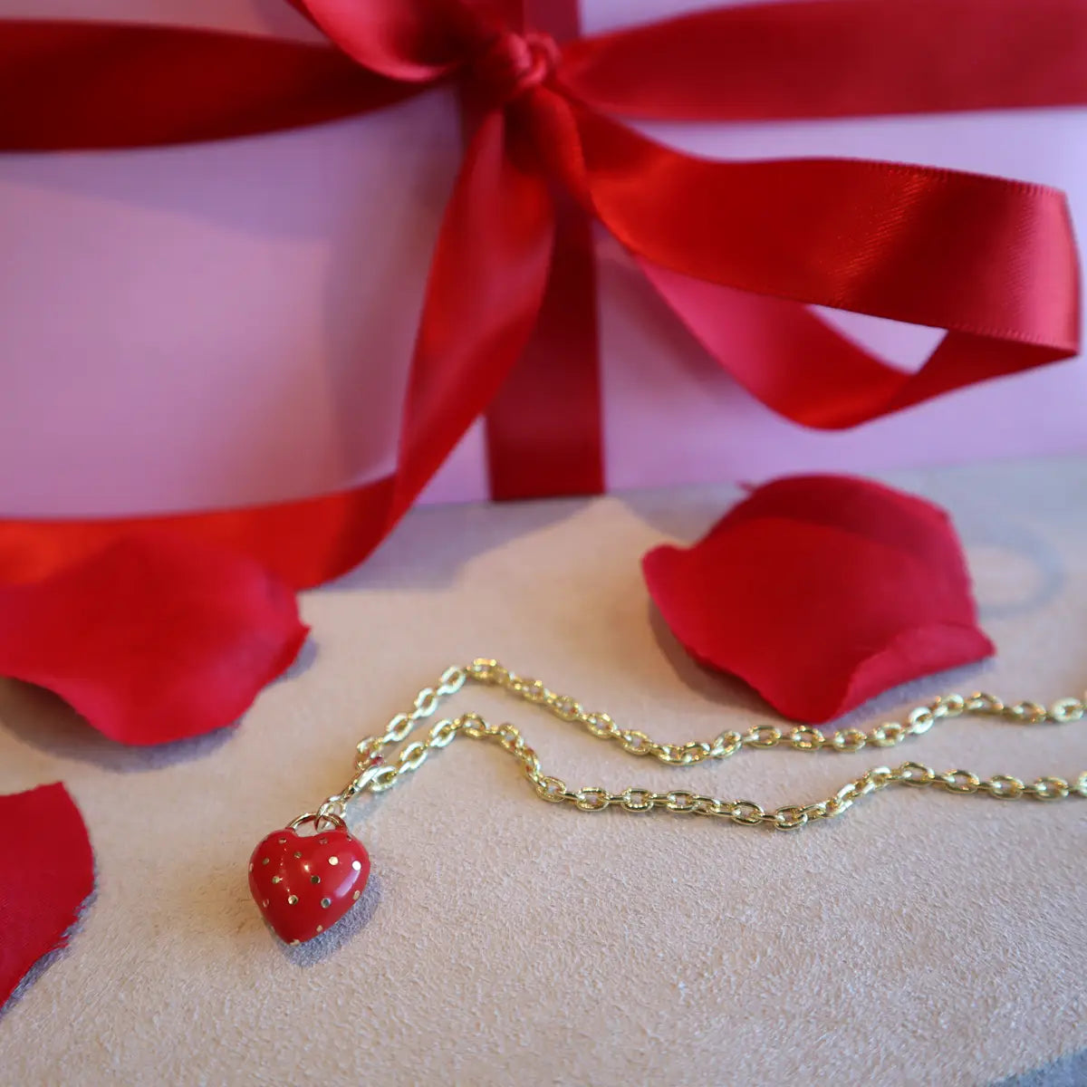 Gorjana red heart link necklace with present behind it