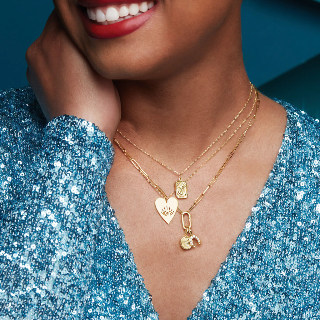 Woman smiling, wearing gold necklaces