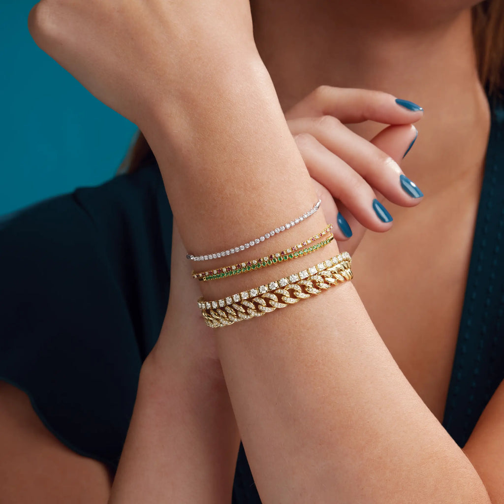 Woman's arm close up wearing various bracelets 