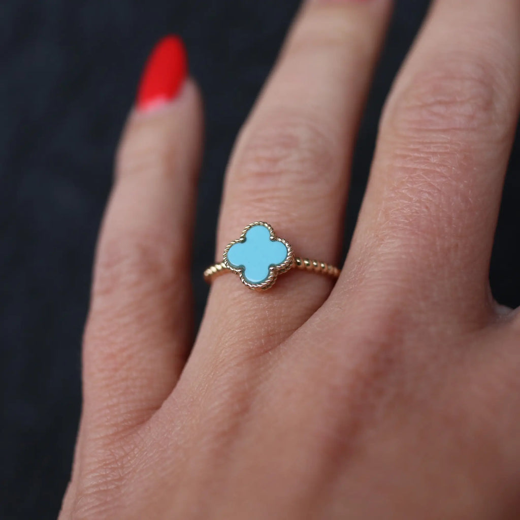 light blue and gold ring on hand