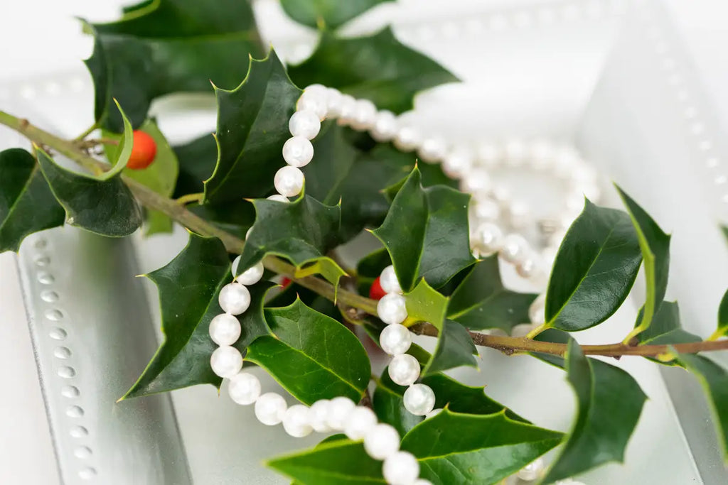 strand of pearls on holly leaves