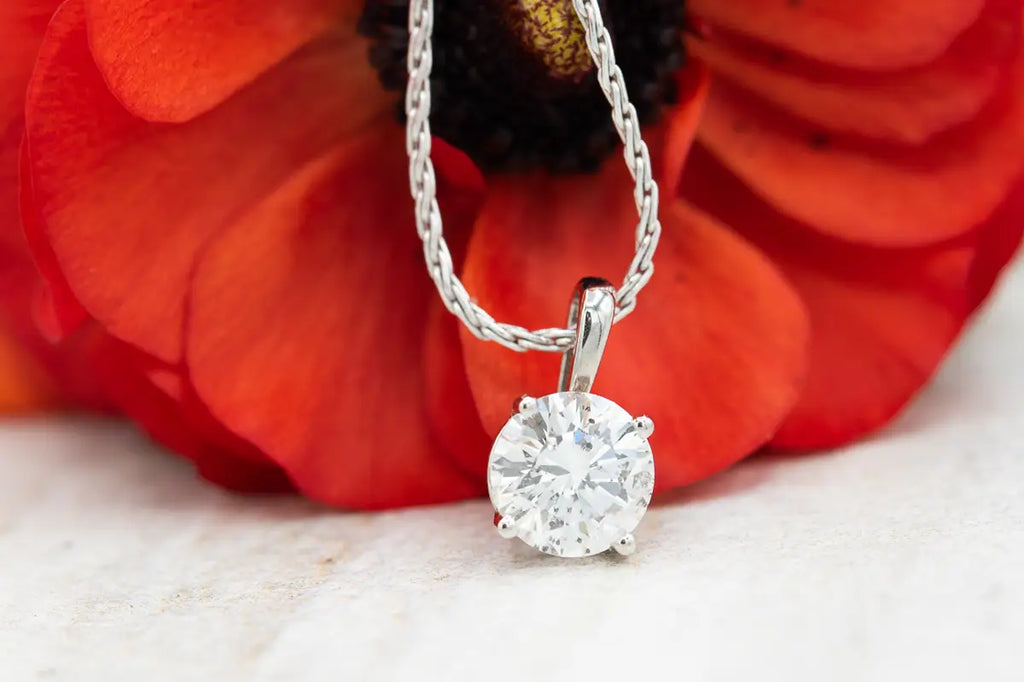 diamond pendant in front of red flower